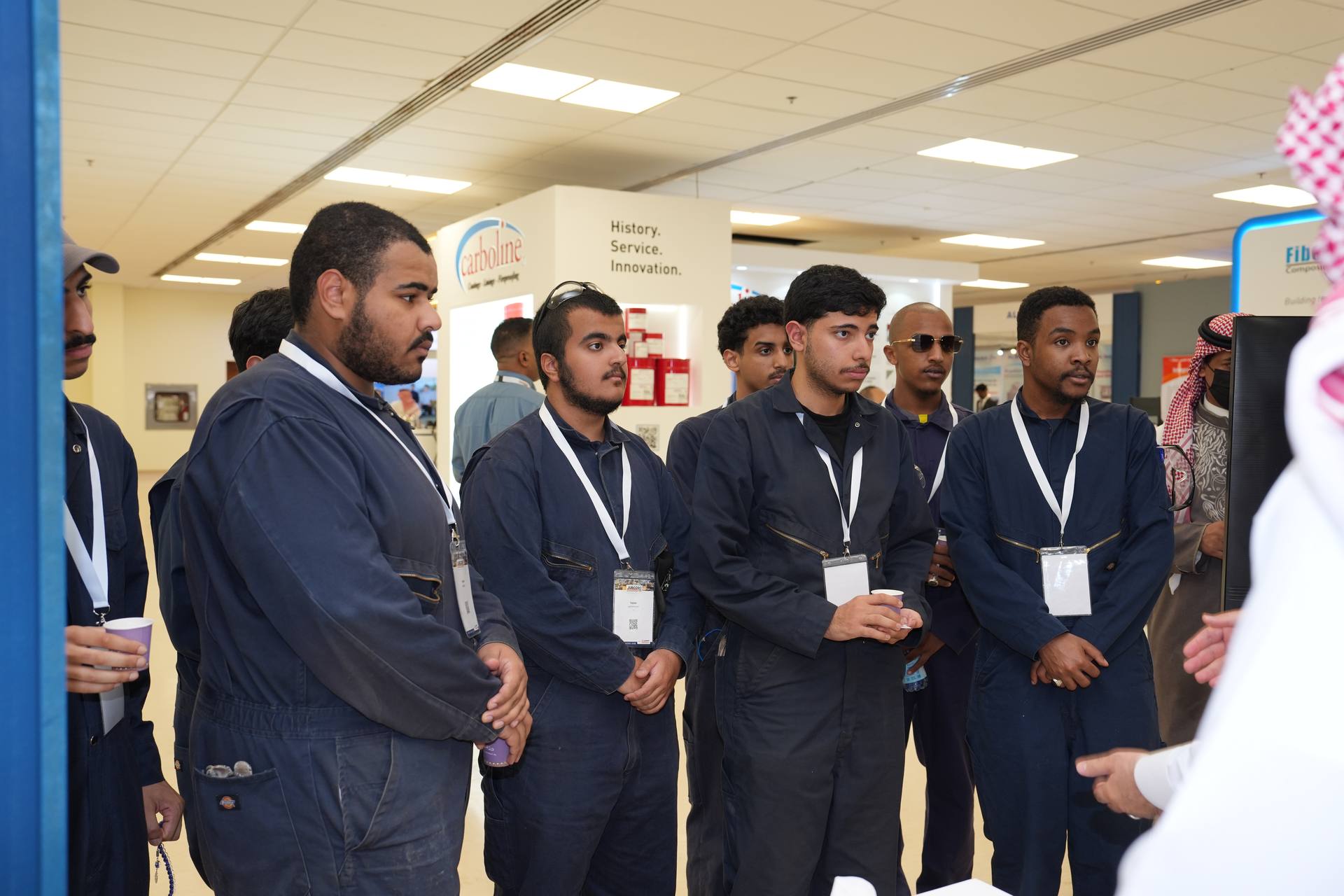 Students examining industrial valve samples at exhibition booth
