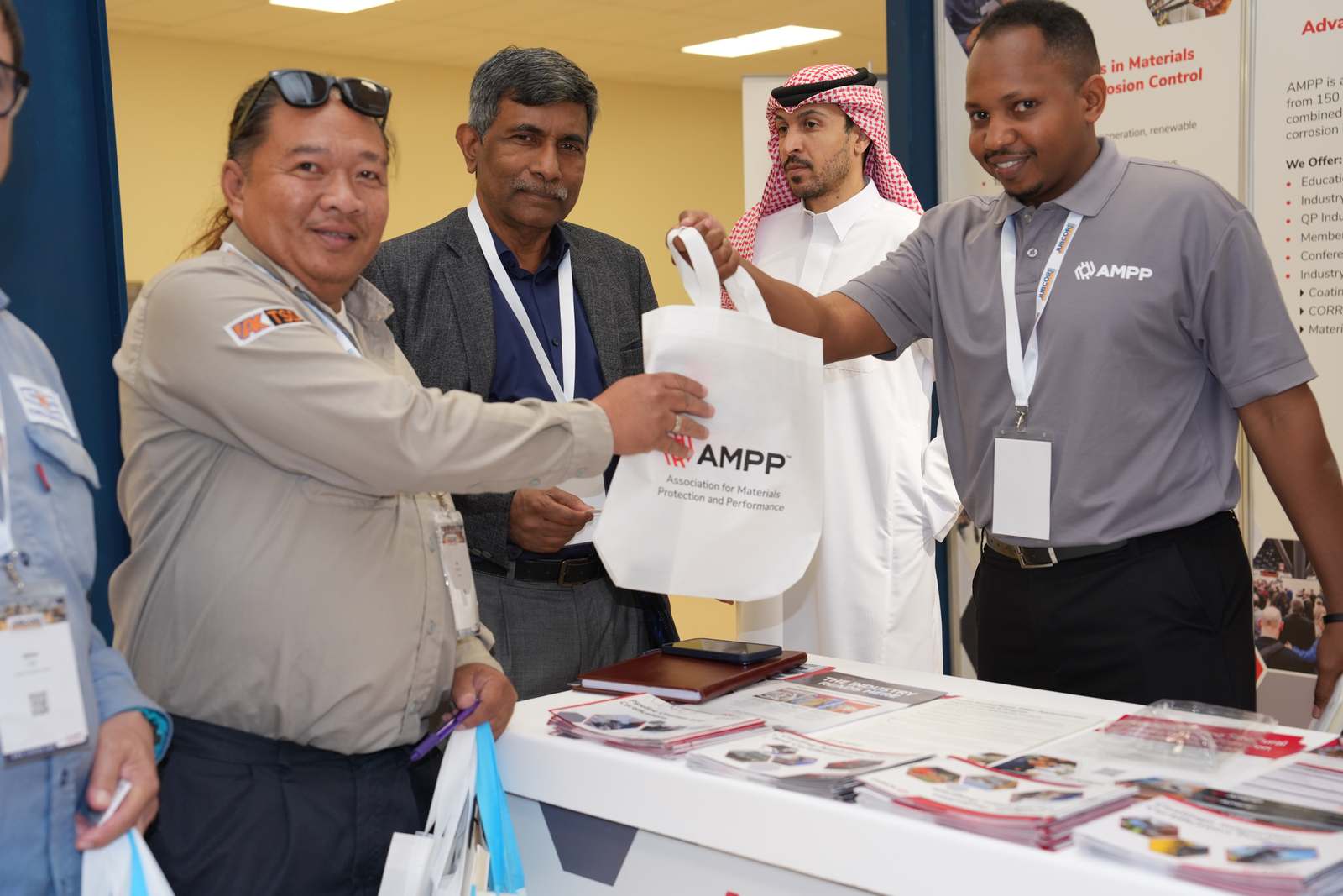 AMPP representative presenting a tote bag at the booth