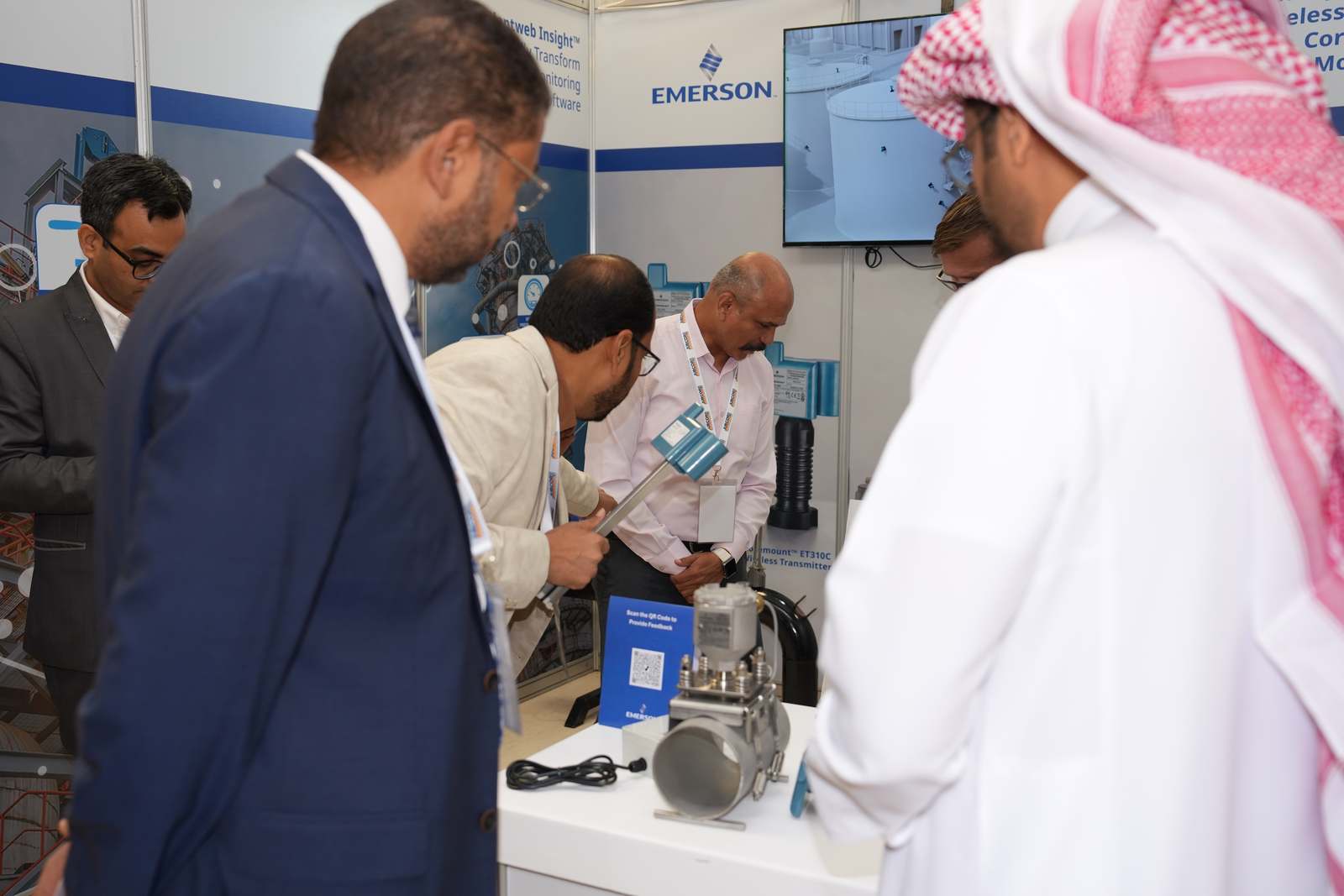 Visitors examining Emerson wireless monitoring equipment