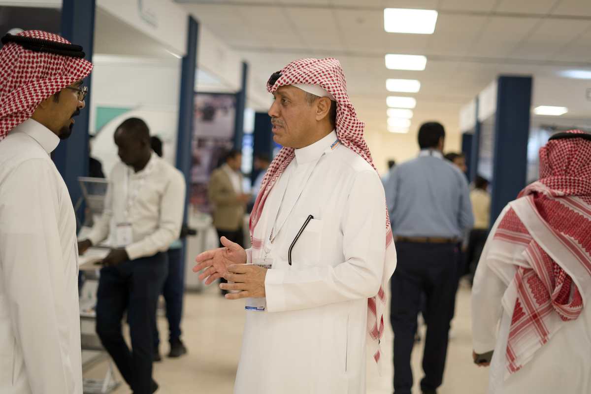 Delegate speaking with an attendee in the exhibition hallway