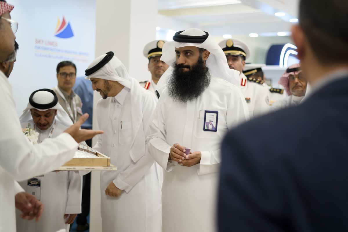 Officials and delegation members at the Sky Lines booth with Arabic coffee