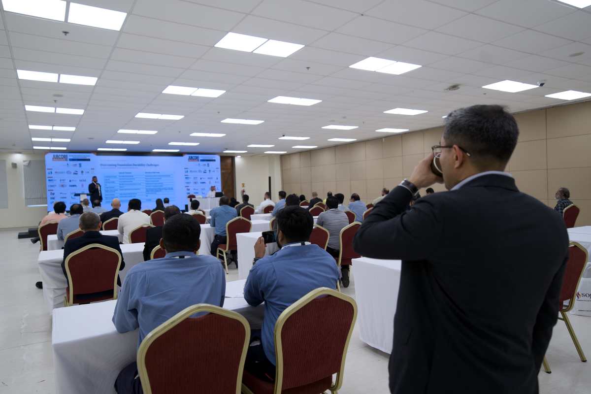 Attendee speaking at a technical session with Jubcor-branded screen