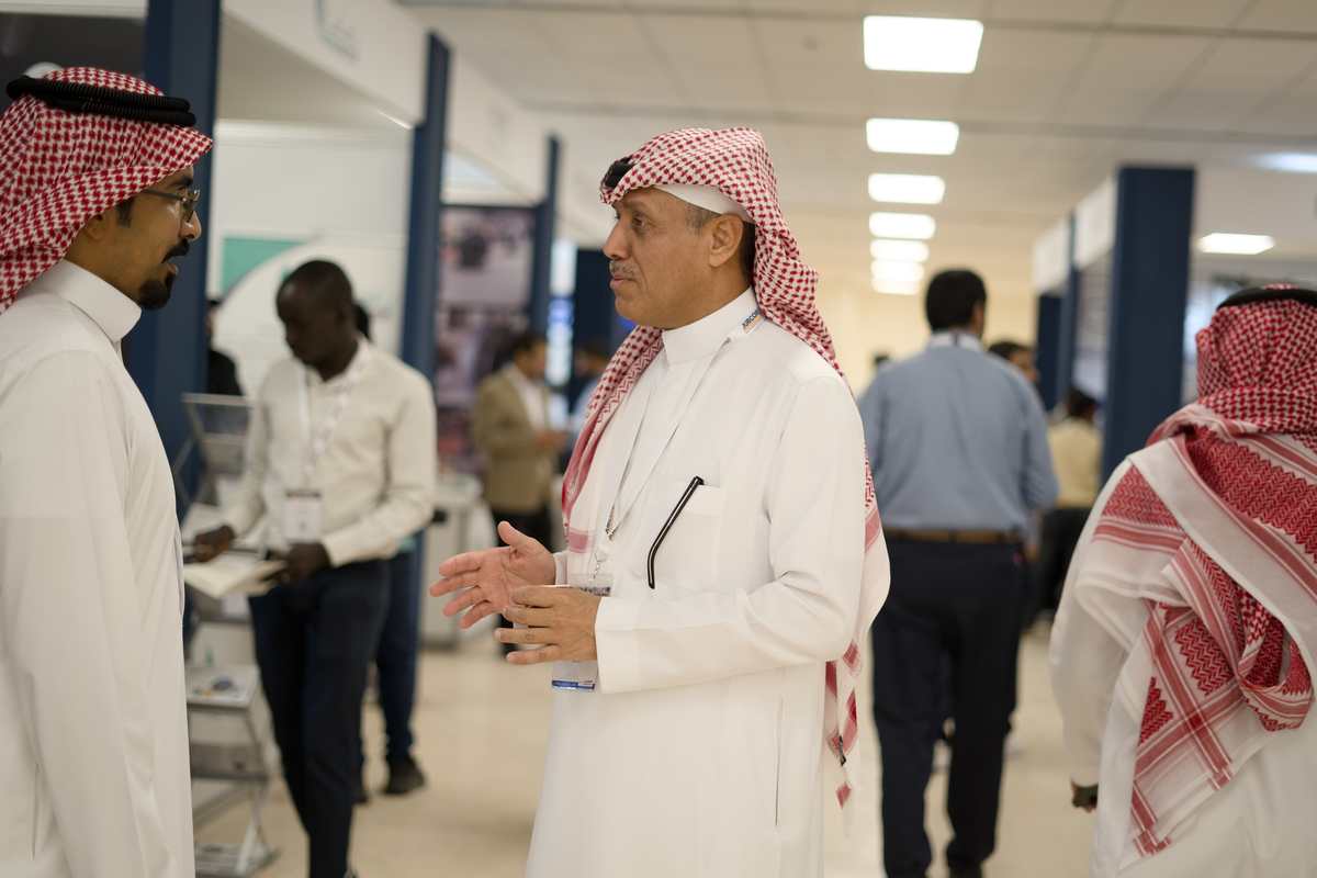 Delegate conversing with an attendee in the exhibition hallway